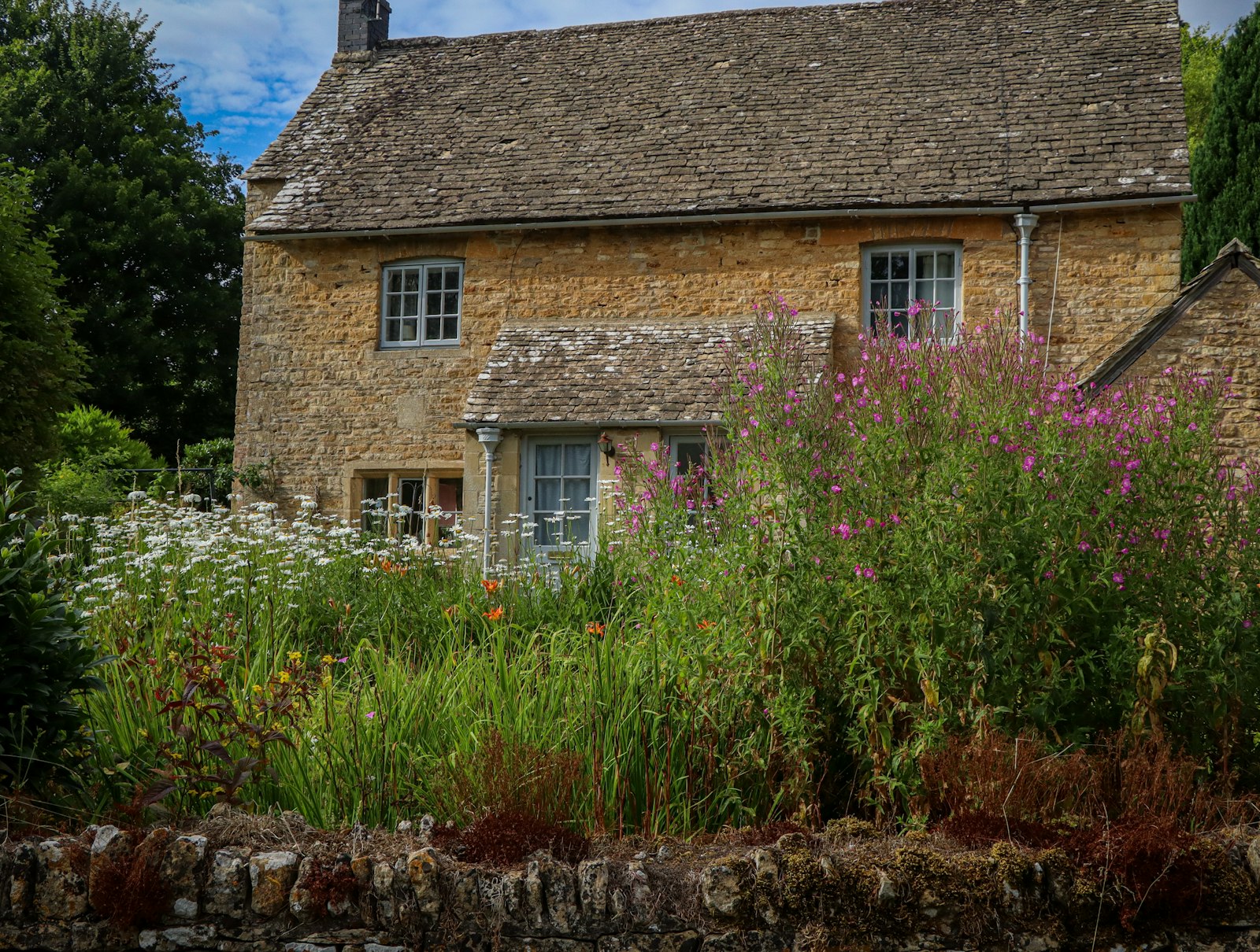 Maison en pierre au jardin fleuri