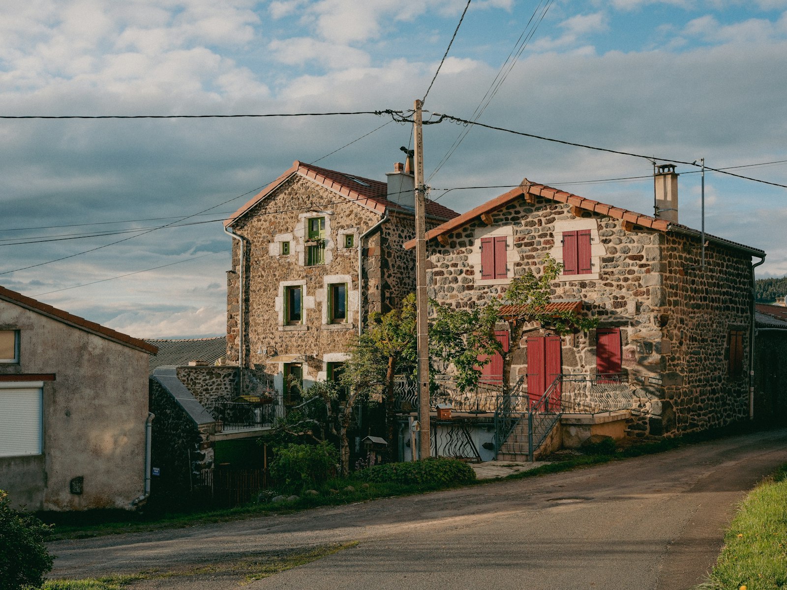 Maisons de village en pierre aux volets rouges